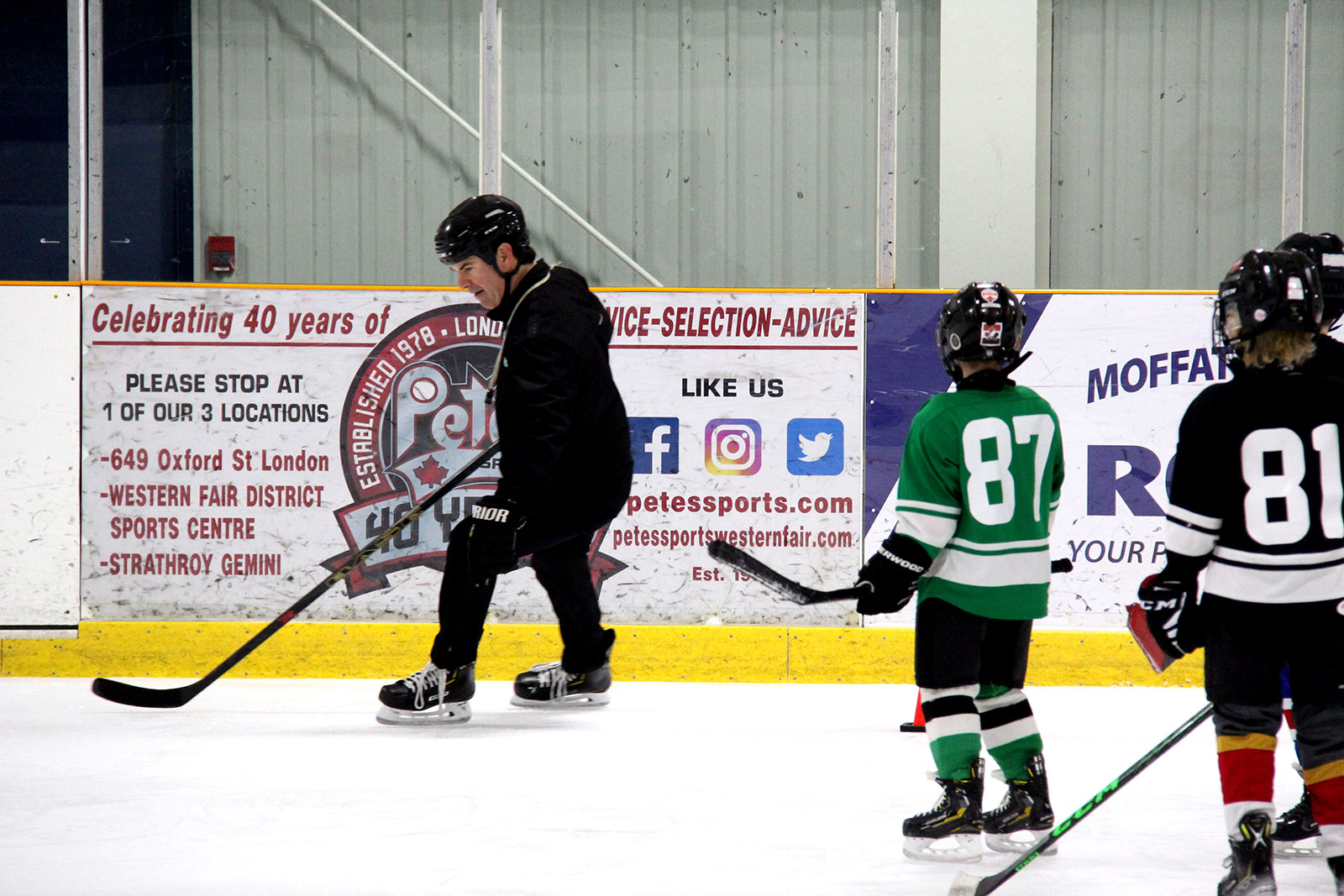 Coach showing kinds how to lean into a turn while skating